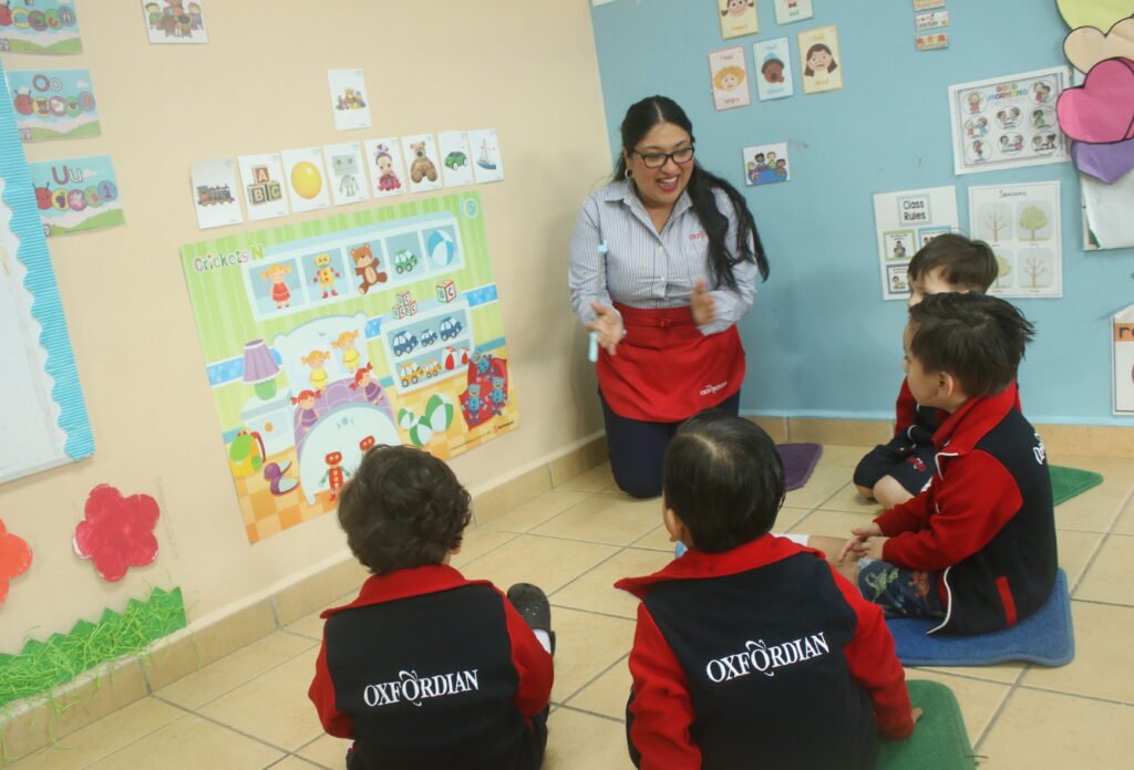 A Las Fuentes teacher reading with Kínder pupils