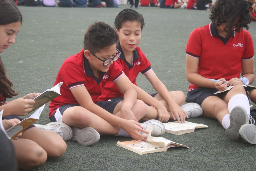 Las Quintas pupils reading together on the grass