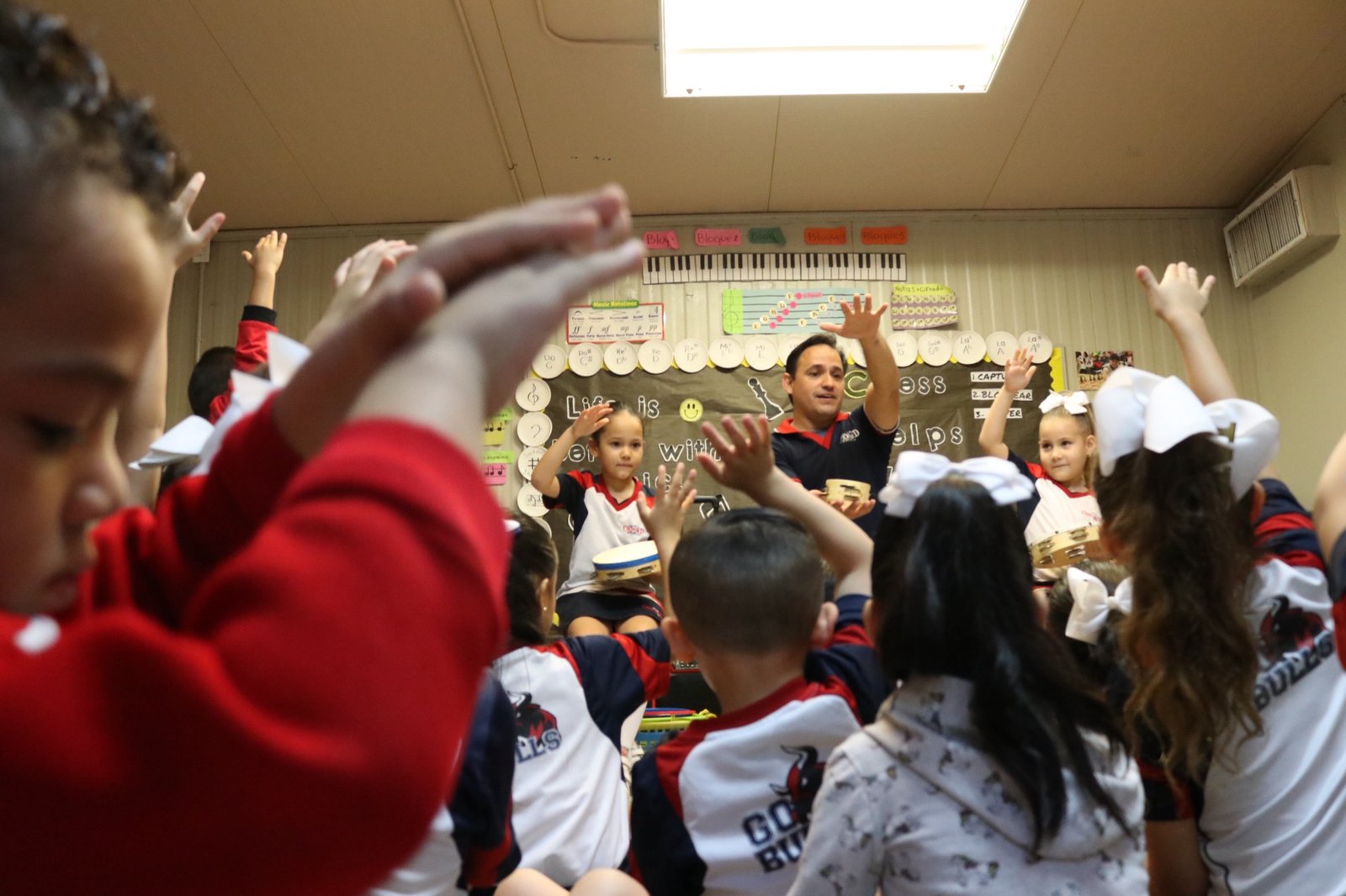 Students raising their hands in music class