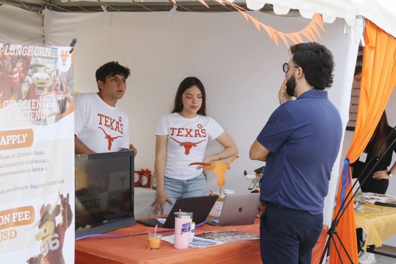 Students discussing a university programme with a visitor at the fair
