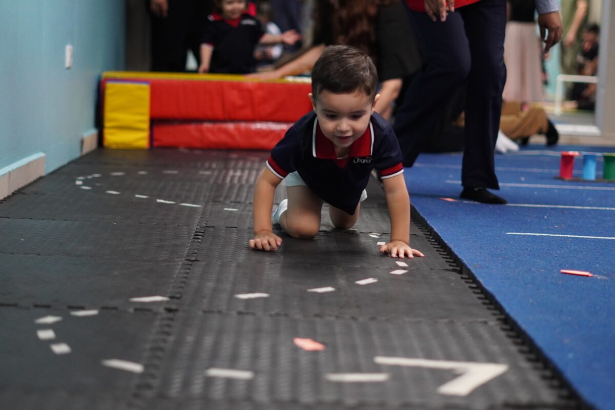 A Las Quintas Nursery pupil crawling through a play course