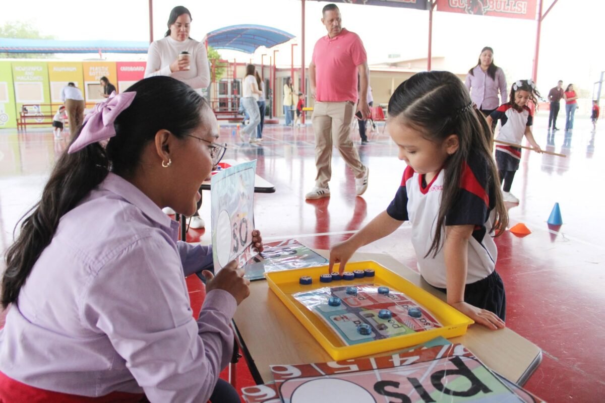A Las Quintas Kínder pupil and teacher at an activity table