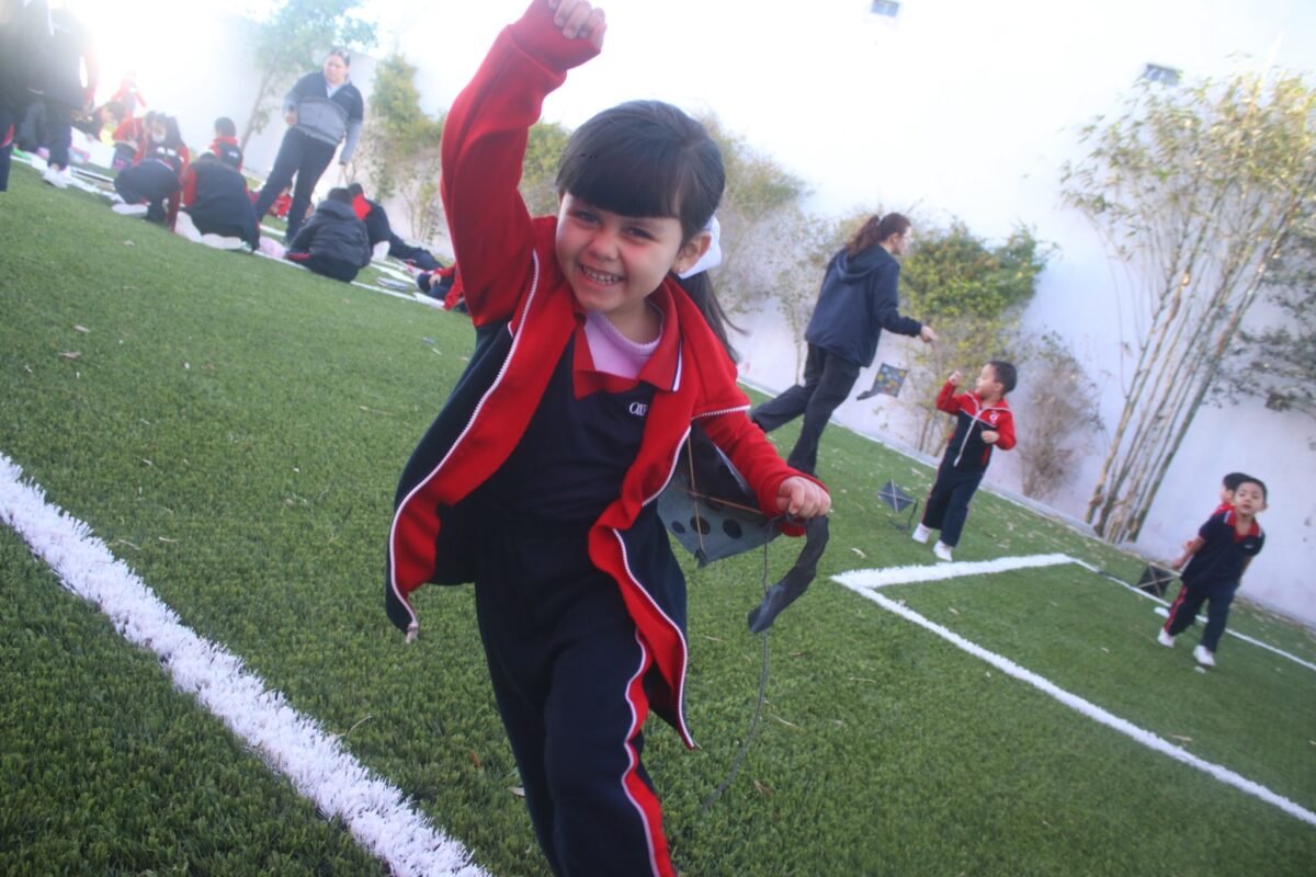Las Fuentes pupil running across the field with a kite