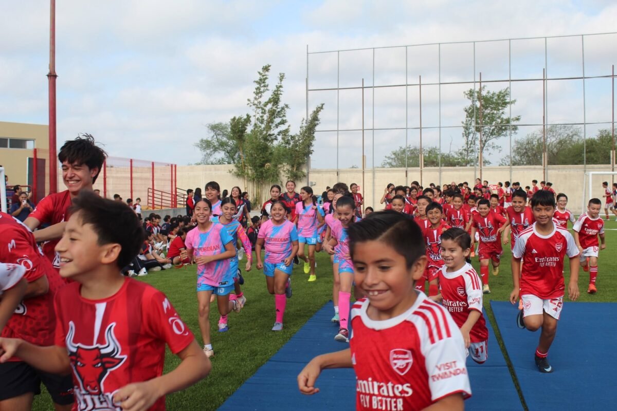 Las Quintas pupils running onto the field in their team jerseys