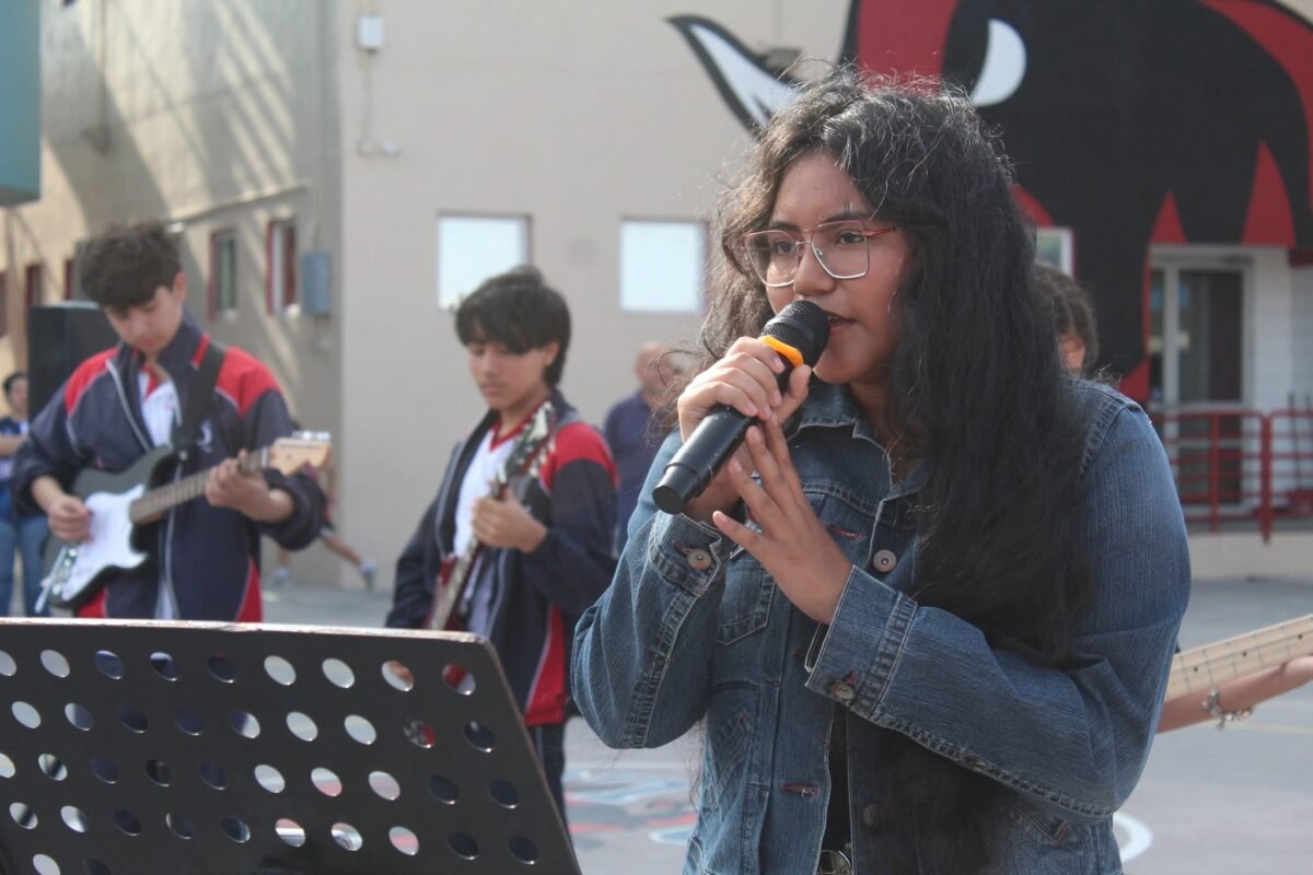 Las Quintas student singing with the school band