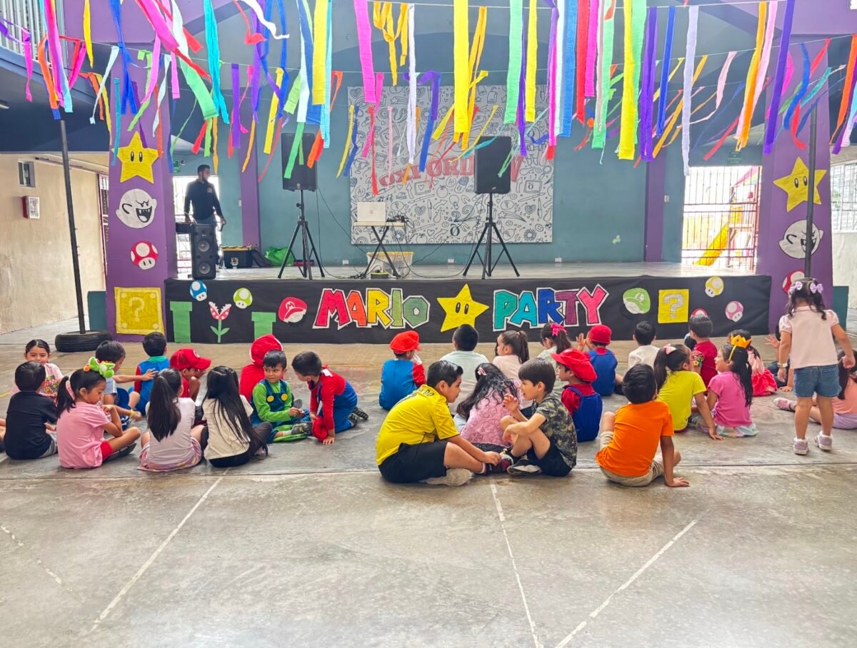 Young pupils in Mario Party costumes gathered in front of the stage