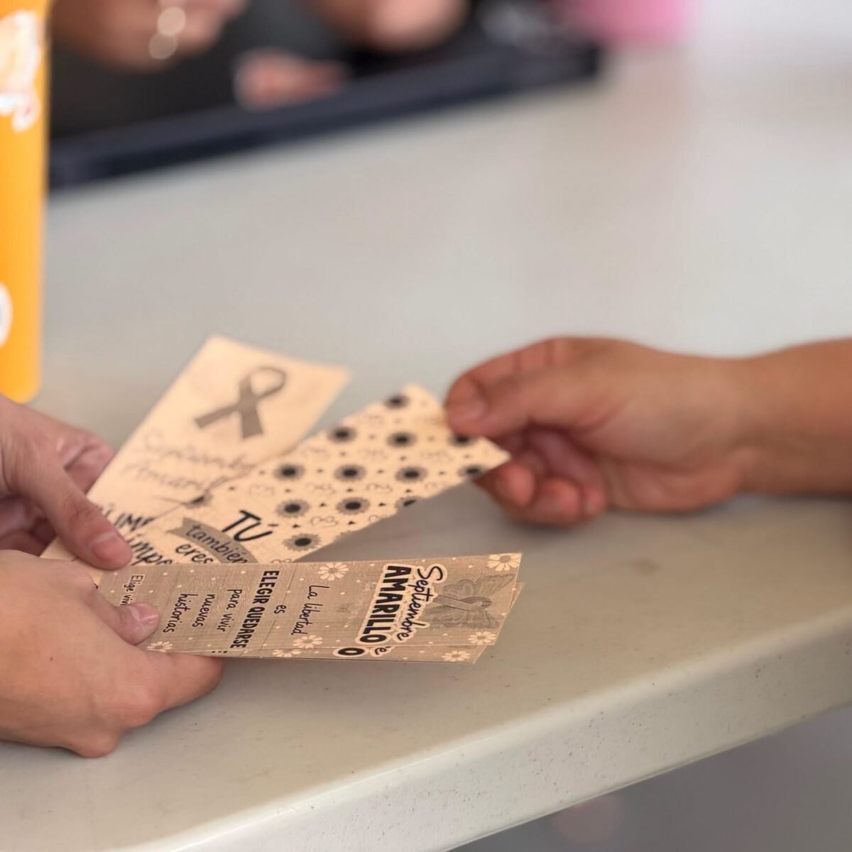 Students holding printed Septiembre Amarillo bookmarks.