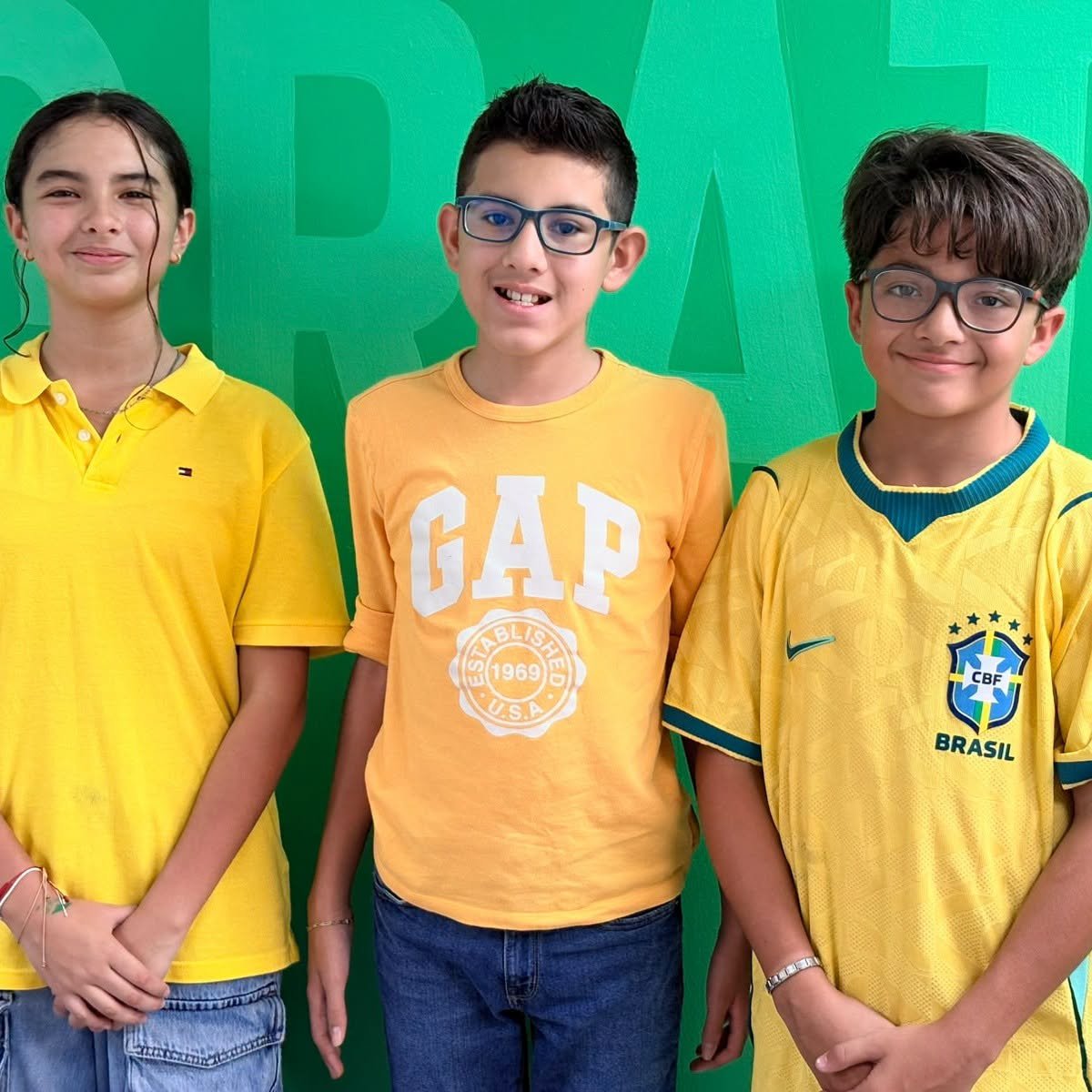 Three students dressed in yellow for Septiembre Amarillo.